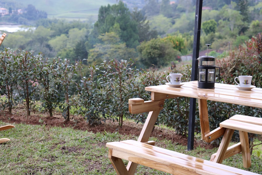 a picnic table with two cups of coffee on it