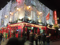 A lively night scene with colorful lights over the beerpong setup.