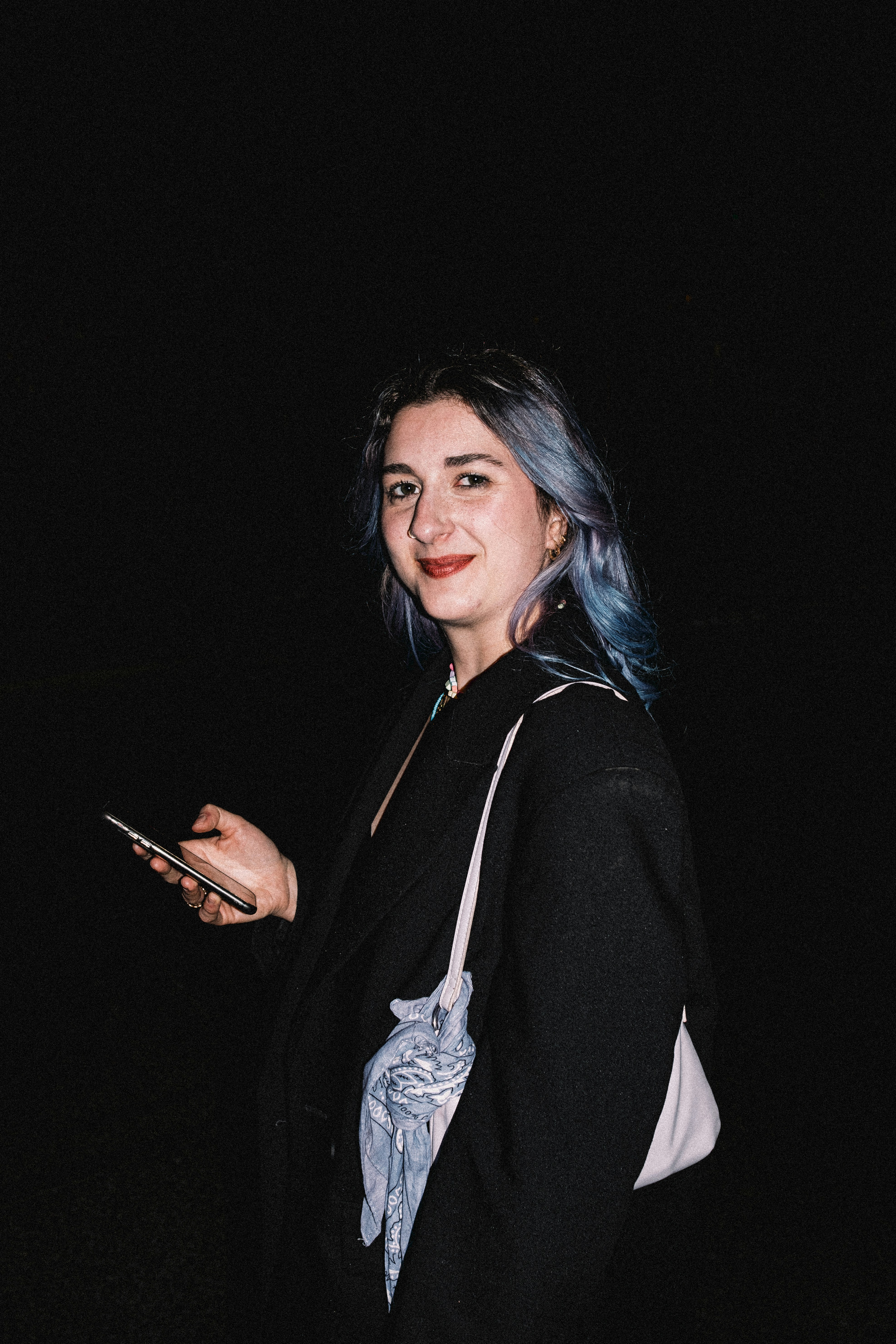 Eine Frau mit blauen Haaren hält ein Handy in der Hand