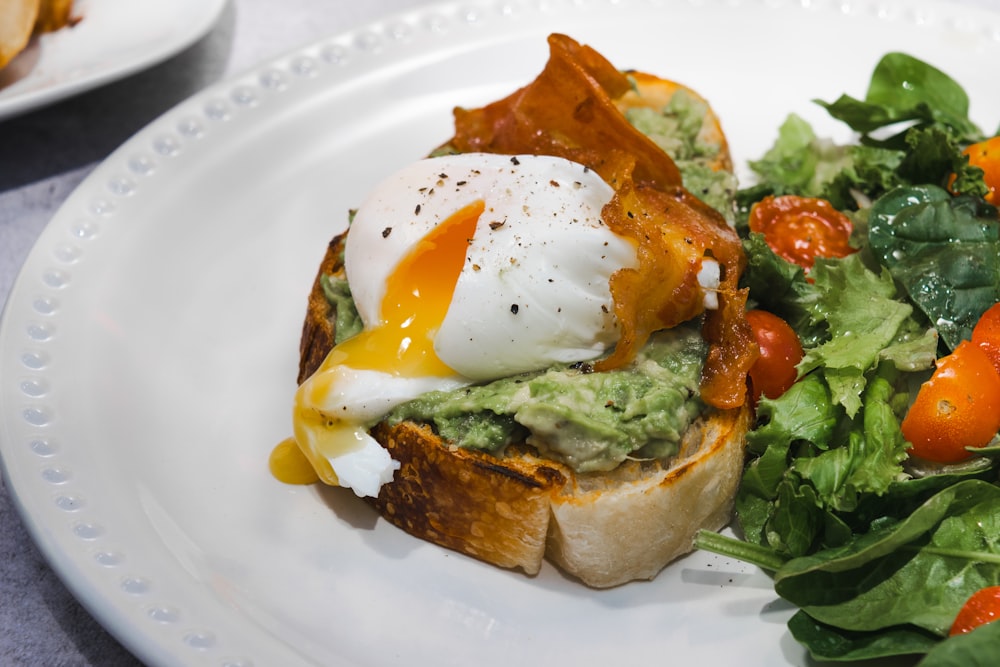 a white plate topped with a salad and an egg