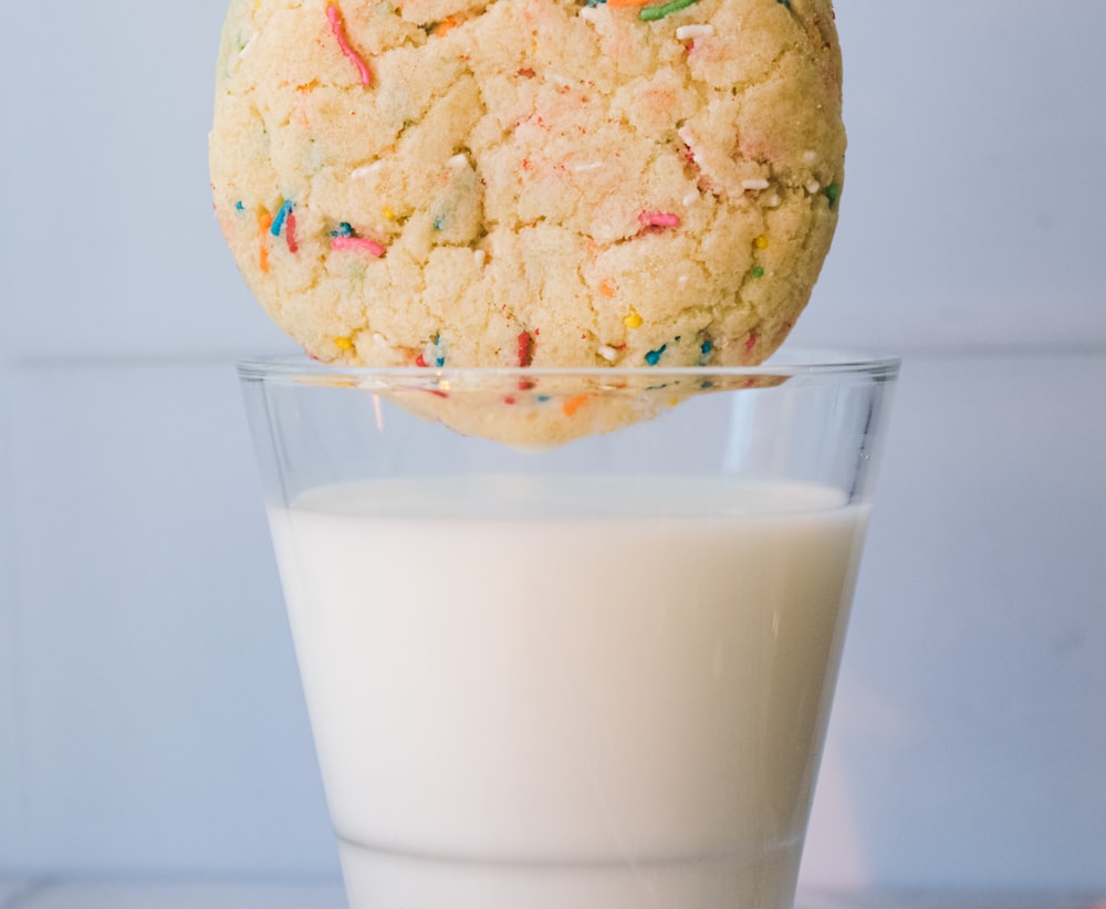 a cookie on top of a glass of milk