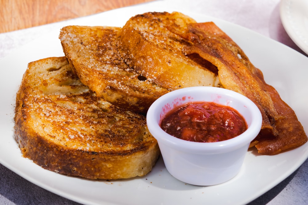 a white plate topped with french toast and ketchup