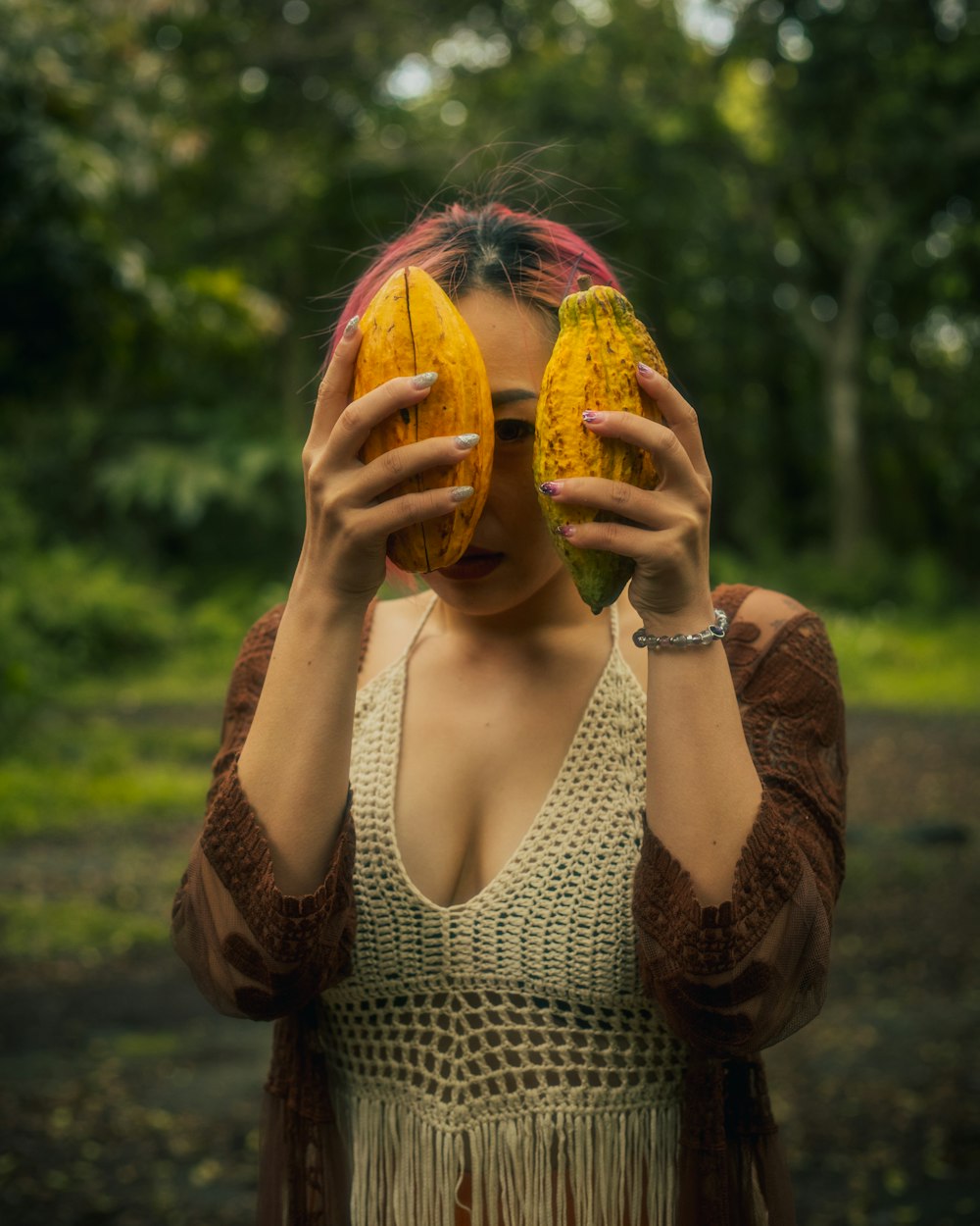 a woman holding two bananas in front of her face