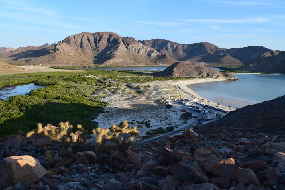 a view of a beach and mountains from a hill