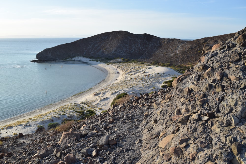 a view of a beach from a rocky cliff