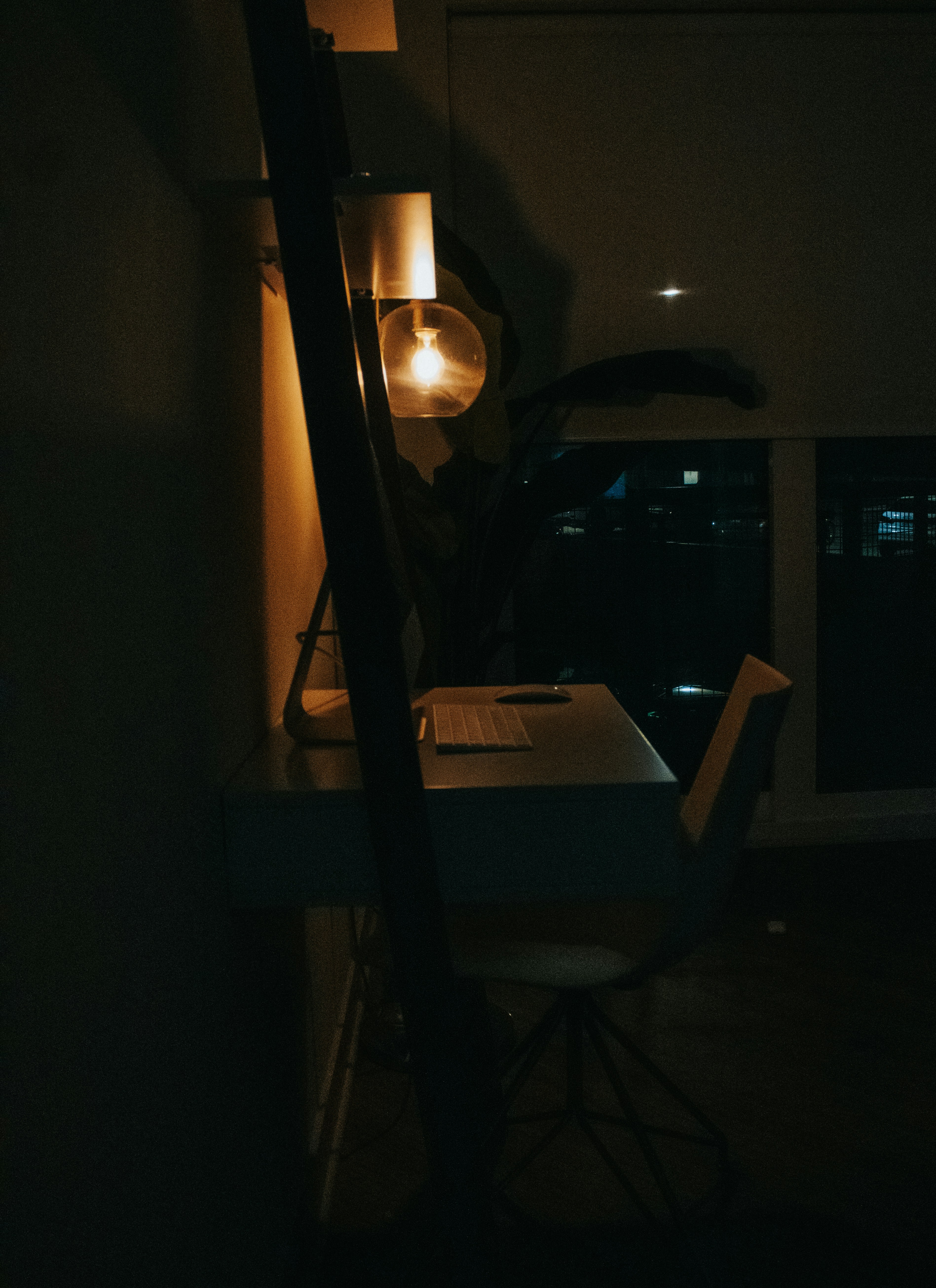 a dark room with a desk and a lamp