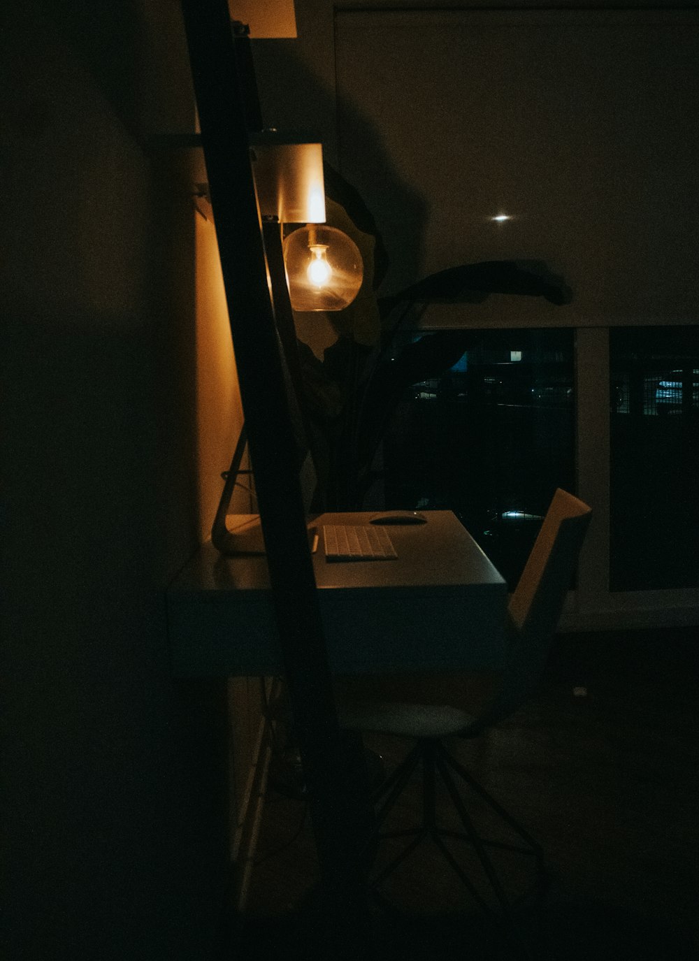 una habitación oscura con un escritorio y una lámpara