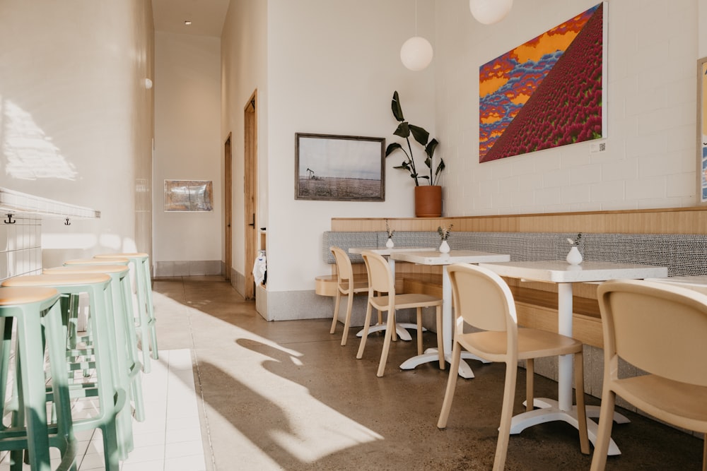 a restaurant with tables and chairs and a painting on the wall