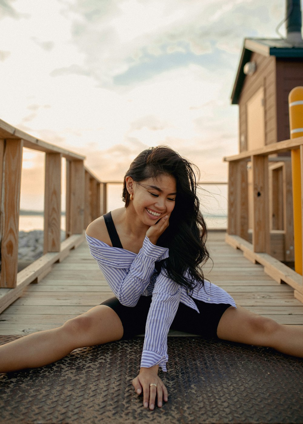 a woman is sitting on a dock smiling