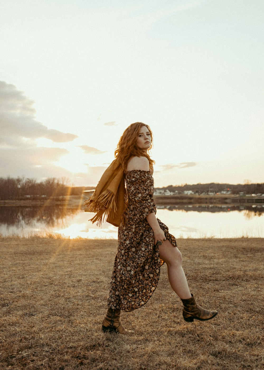 a woman in a dress is walking in a field