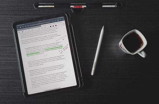 a tablet computer sitting on top of a desk next to a cup of coffee