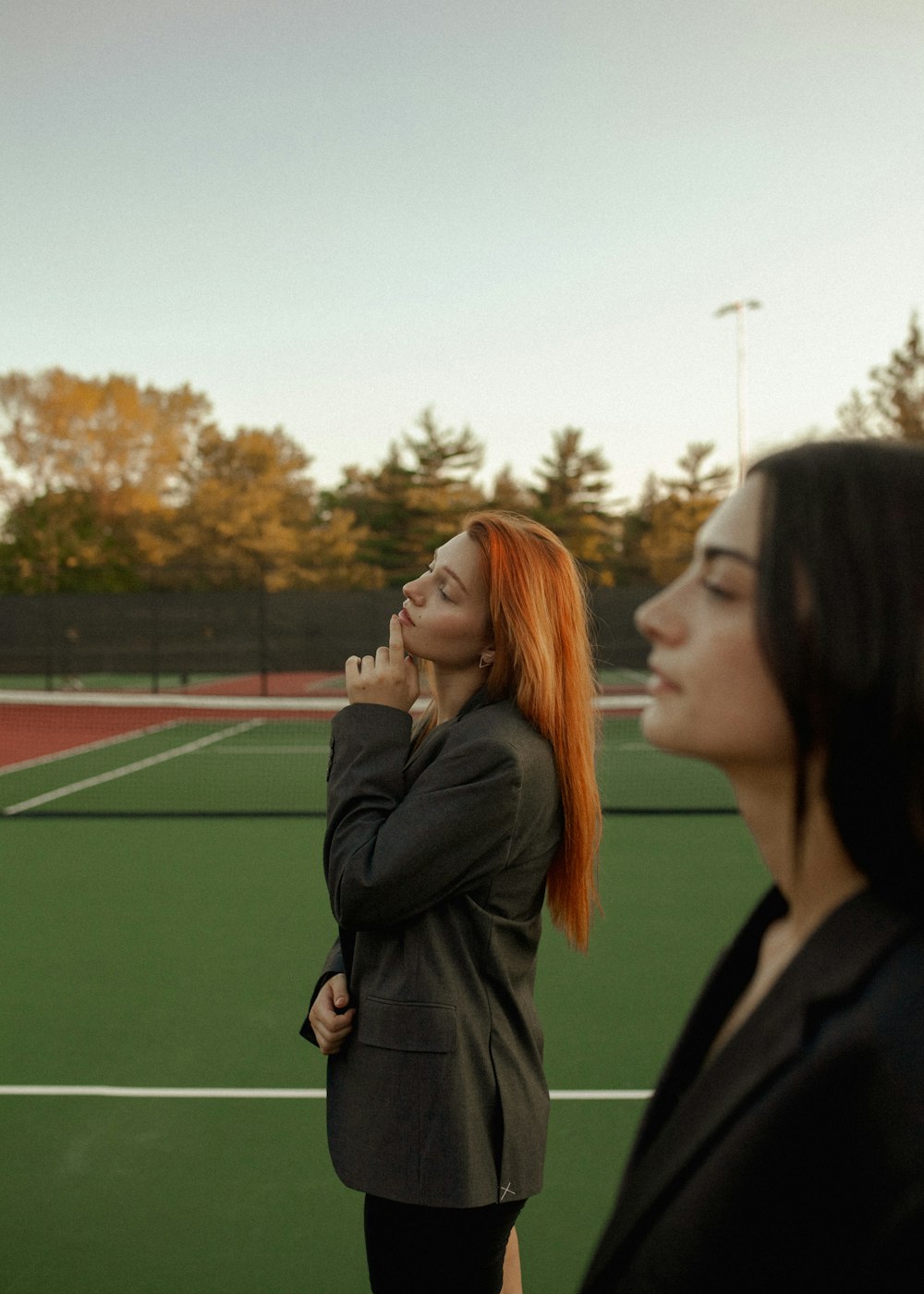 two women are standing on a tennis court