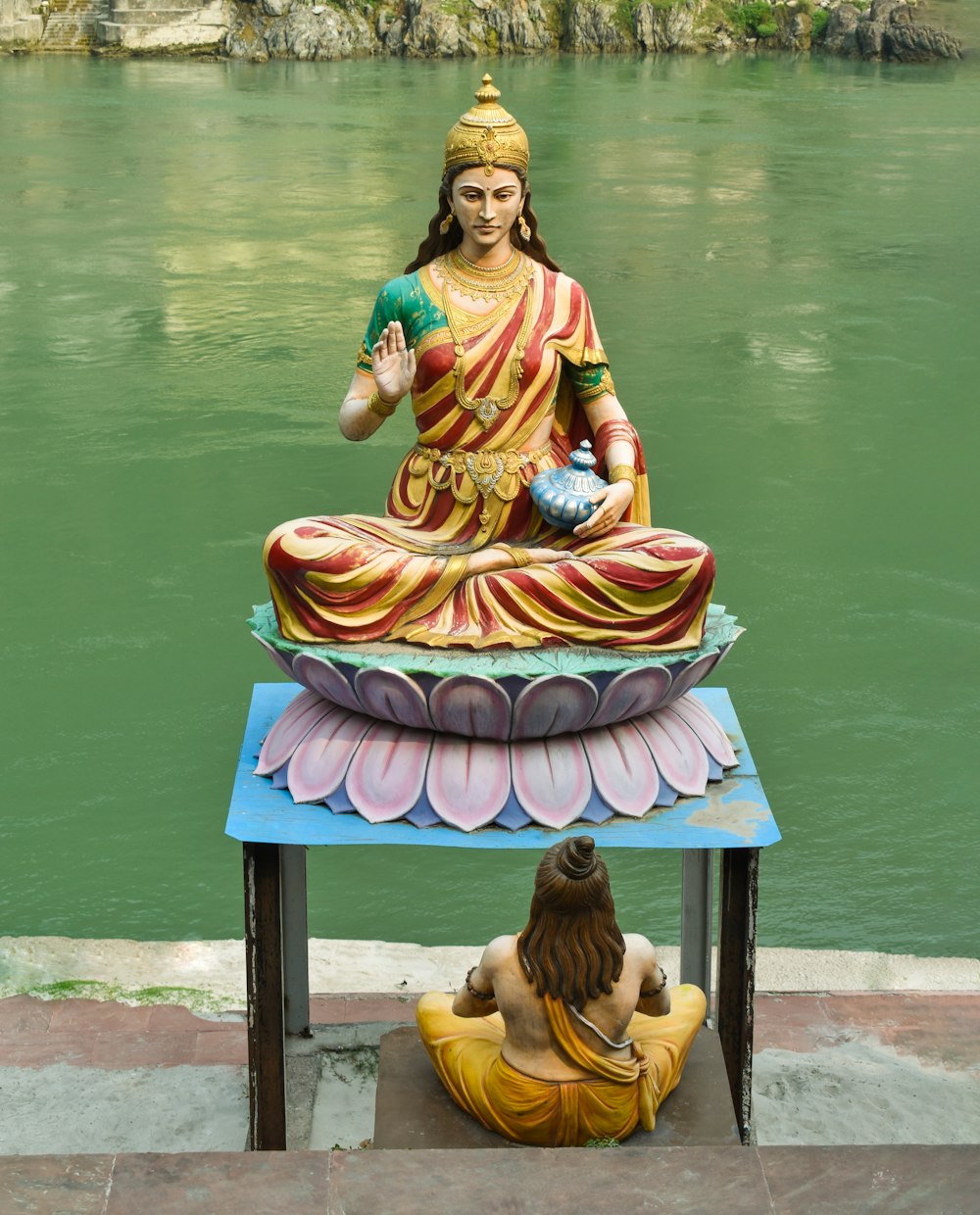 Eine Statue eines Buddha, der auf einem Tisch neben einem Körper von