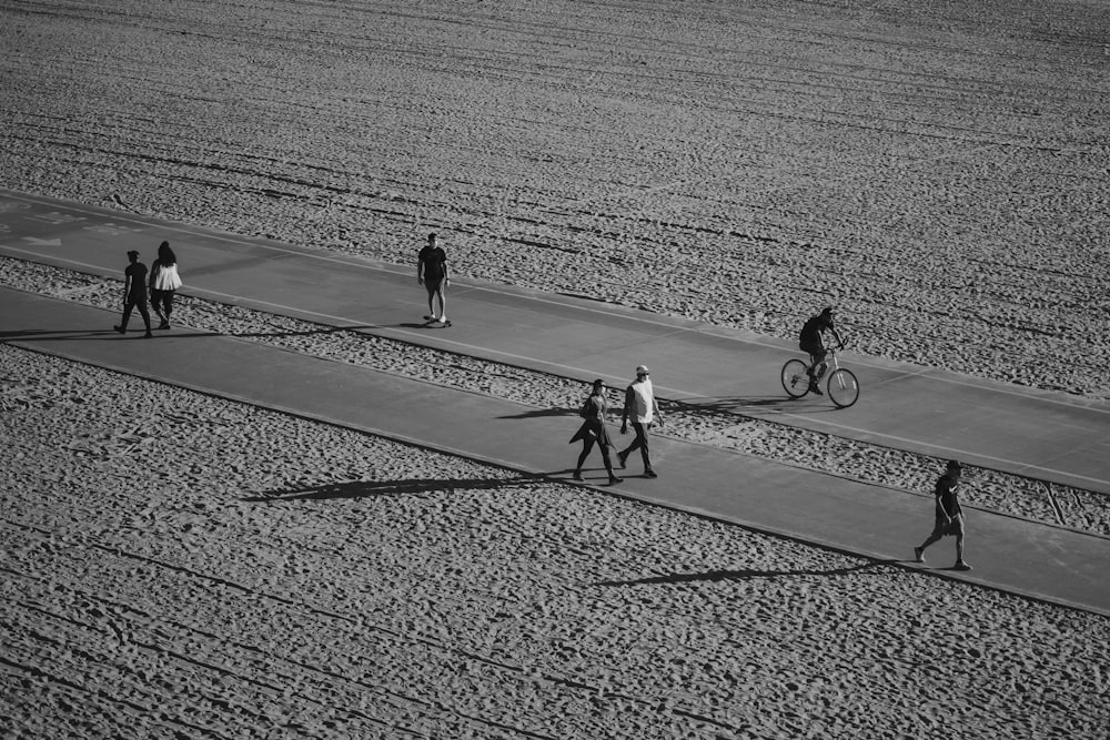 a black and white photo of people walking and riding bikes