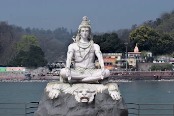 a statue of a person sitting on top of a rock