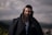 a man with long hair and a beard wearing a black jacket