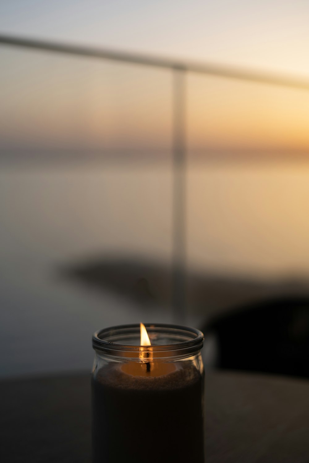 a lit candle sitting on top of a wooden table