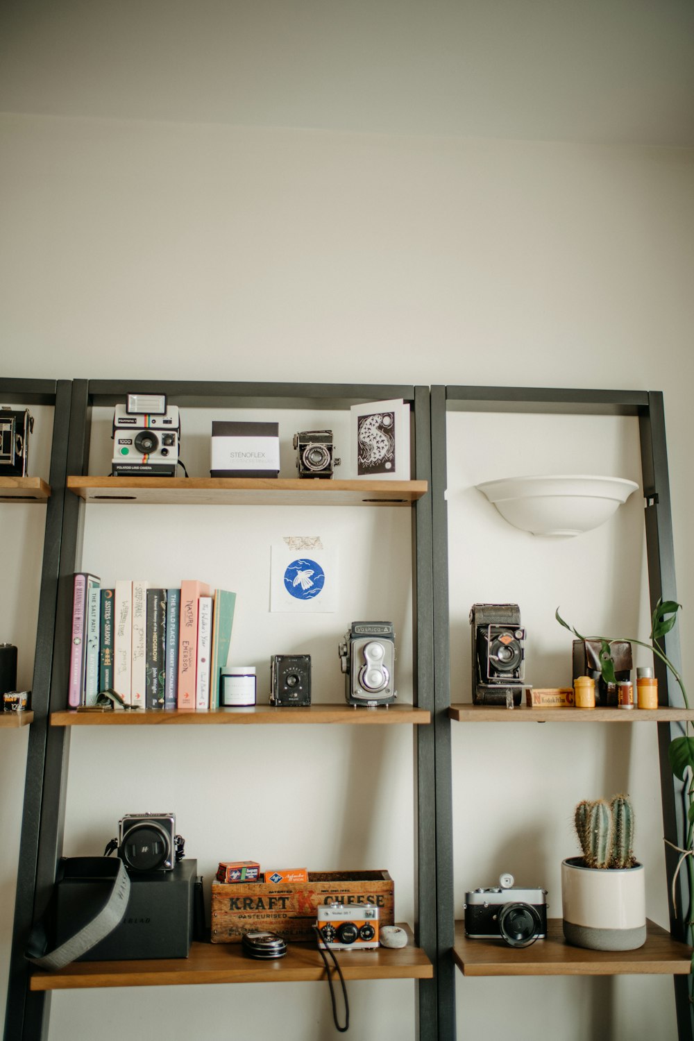 a bookshelf filled with lots of books next to a wall