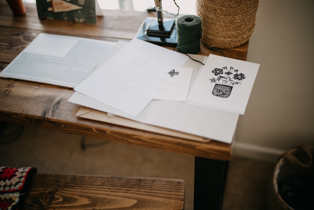 a wooden table topped with lots of papers