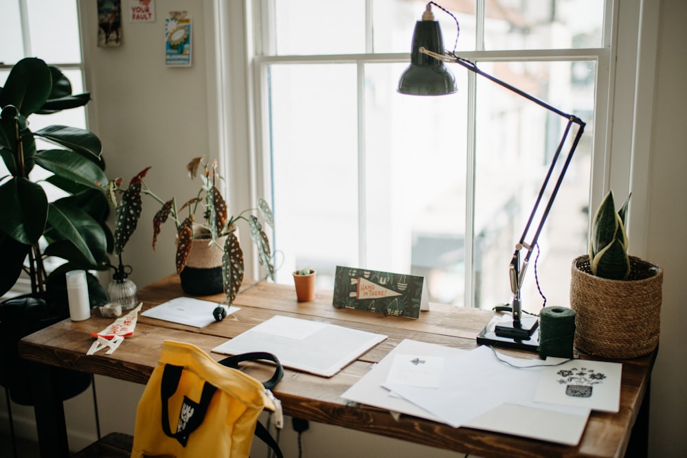 a desk with a lamp, books, and papers on it