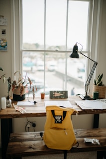 a yellow backpack sitting on top of a wooden table