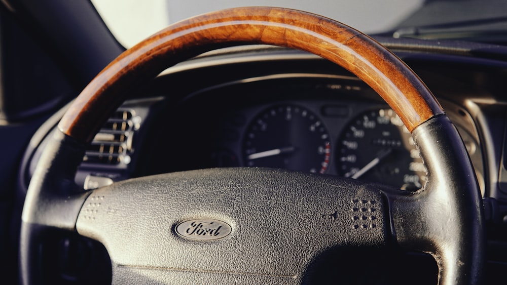 a steering wheel of a car with a wooden dashboard