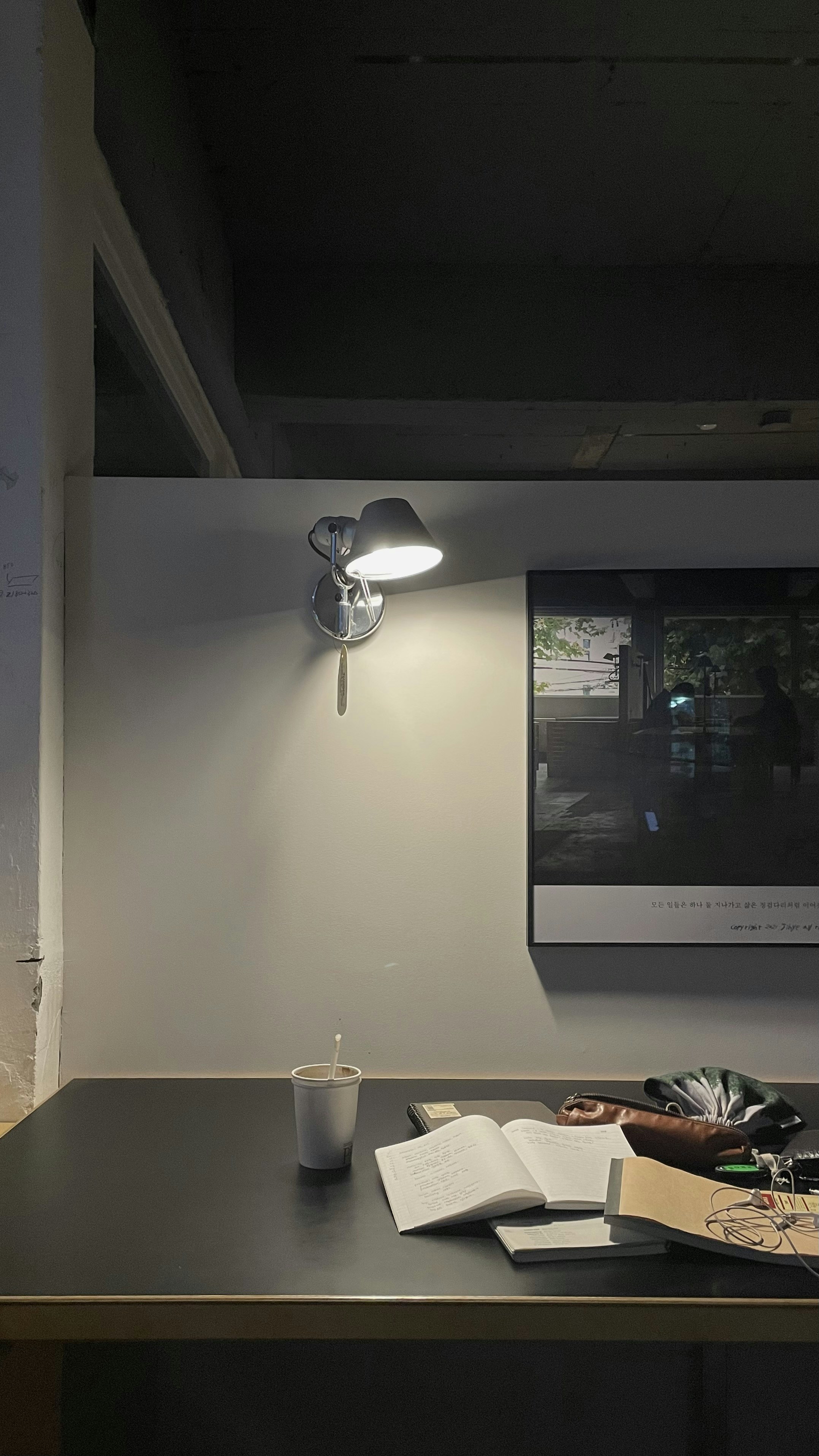 Open book with poetry on wooden desk, warm reading lamp