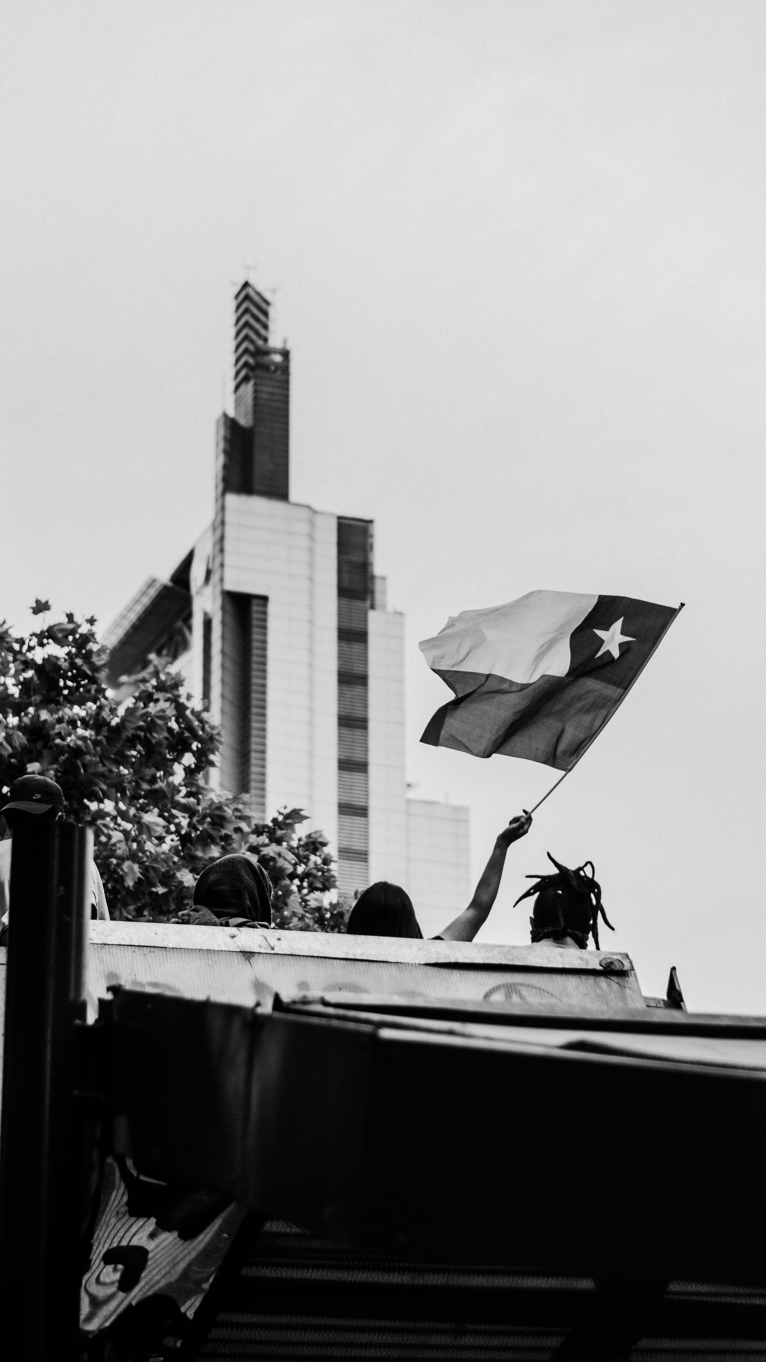 Una foto en blanco y negro de una bandera en la parte superior de un edificio
