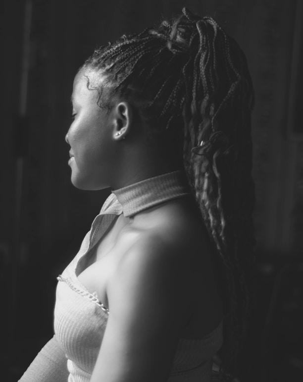 a black and white photo of a woman with dreadlocks
