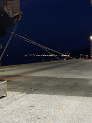 Nighttime view of a ship docked with survey equipment set up nearby.