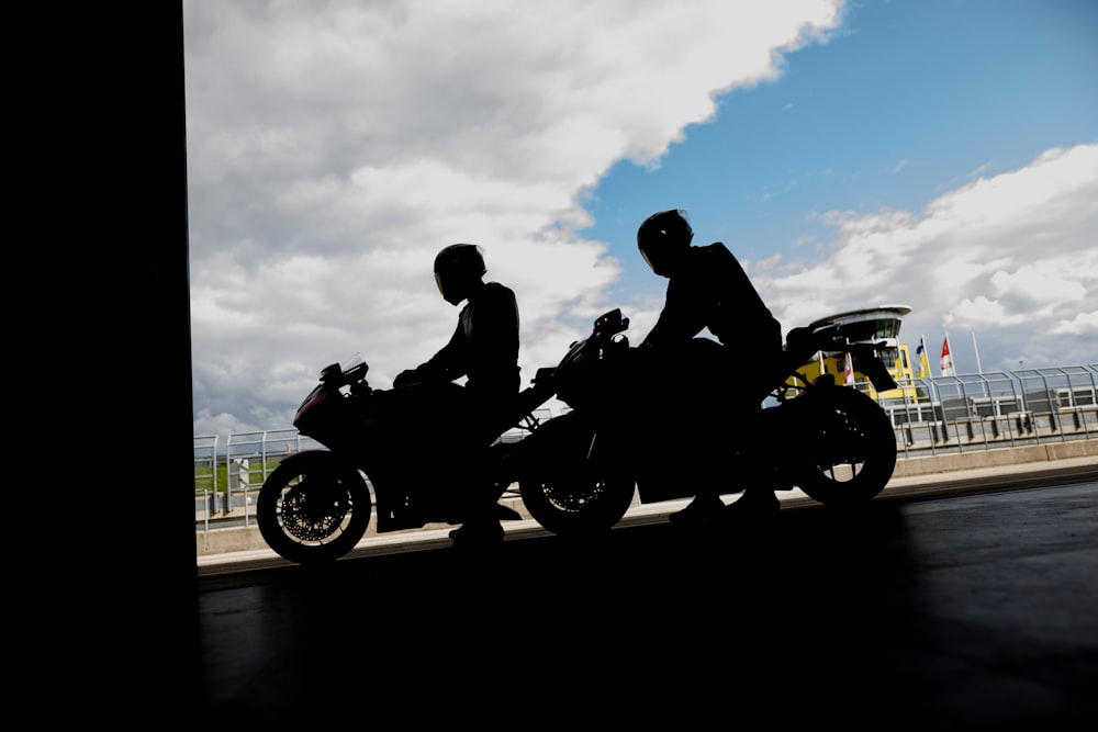 a couple of people riding on the back of motorcycles