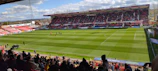 A panoramic view of a modern stadium filled with excited spectators on match day.