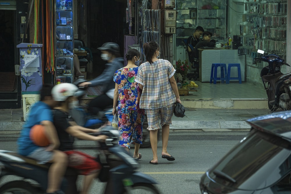 a group of people riding scooters down a street