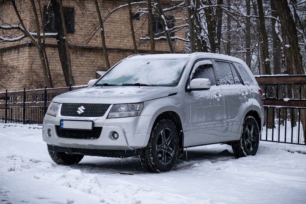 a white suv is parked in the snow