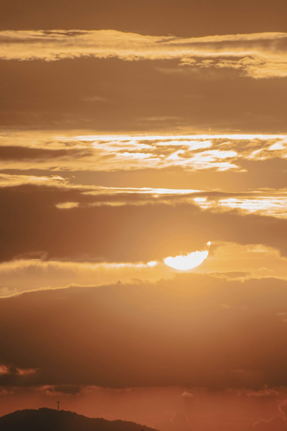 a plane flying in the sky at sunset