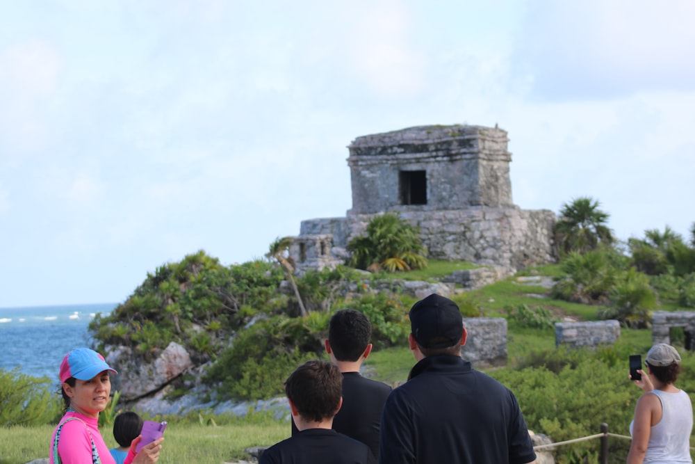 a group of people standing in front of a stone structure