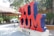 Large red and blue 3D letters spell out 'TULUM' with a hashtag symbol at the top. The background shows a thatched-roof structure and lush greenery, while a decorative zebra painted with skeletal patterns stands nearby.
