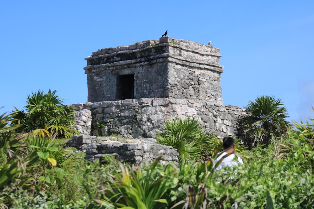 a person standing in front of a stone structure