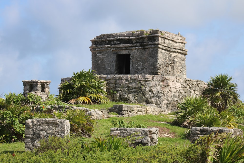 a stone structure with a door on top of a hill