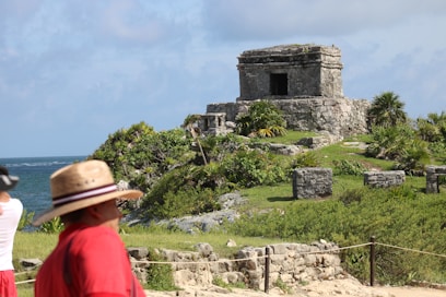a man and a woman standing in front of a stone structure