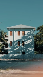 a large white building with many windows and a fence