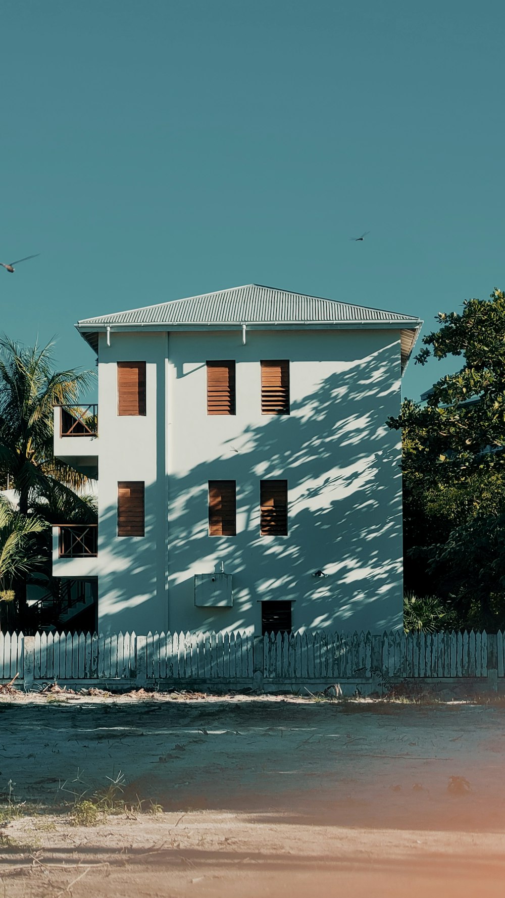 a large white building with many windows and a fence