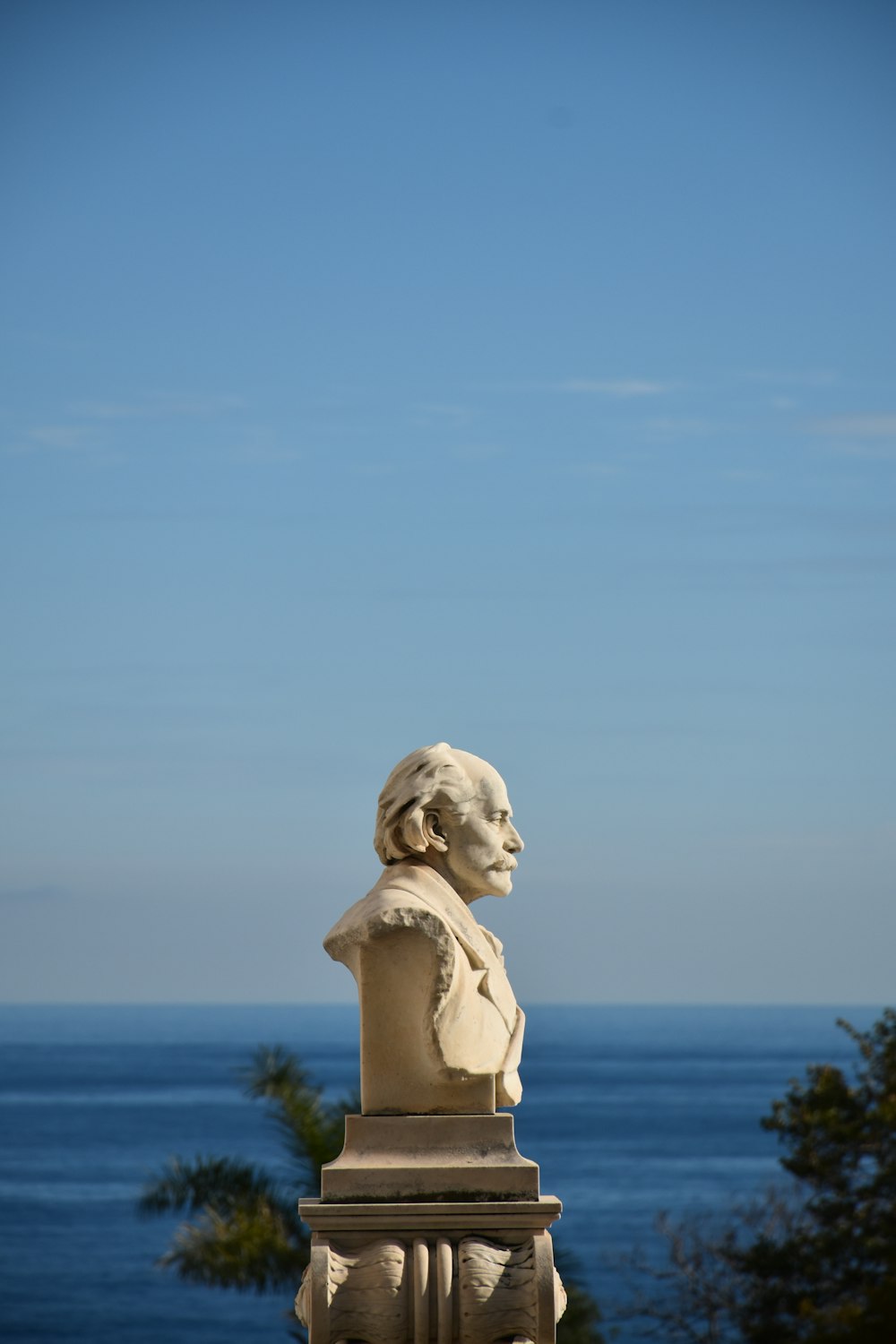 une statue d’un homme avec une barbe au sommet d’un bâtiment