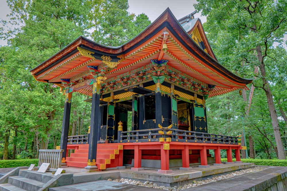 a red and black pagoda with steps leading up to it