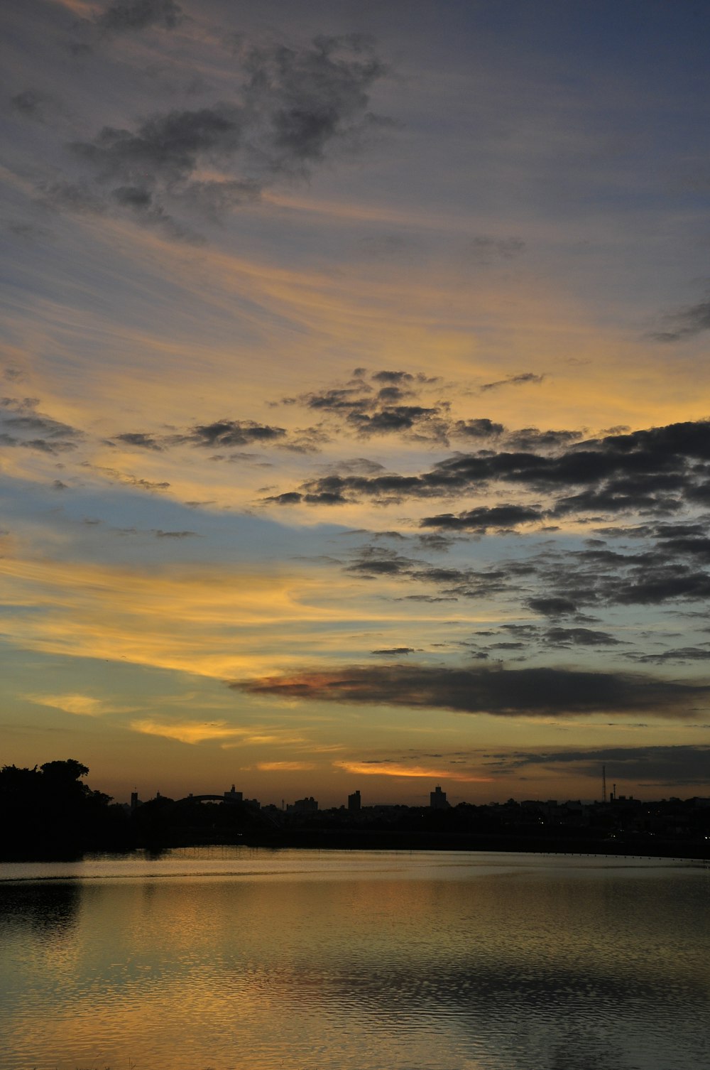 Un tramonto su uno specchio d'acqua con nuvole nel cielo