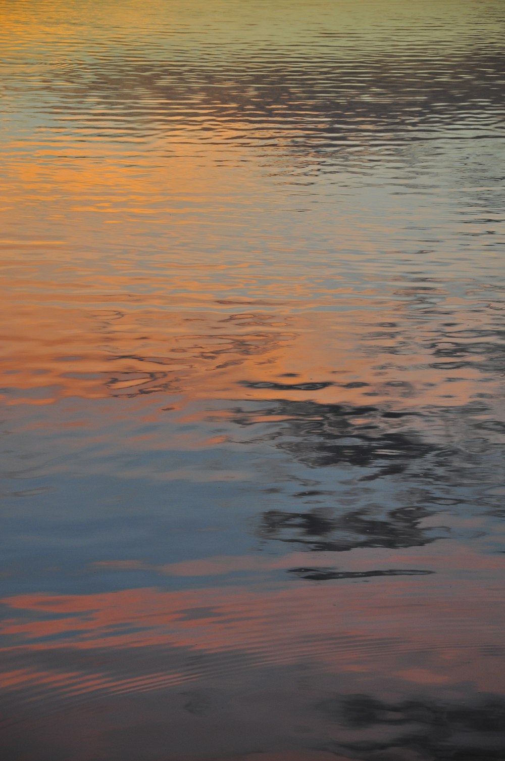 Un grande specchio d'acqua con un tramonto sullo sfondo