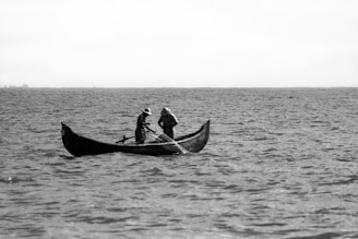 two people in a boat on a large body of water