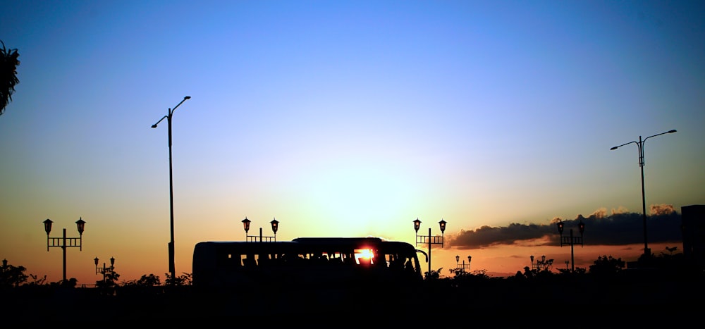 a bus driving down a street at sunset