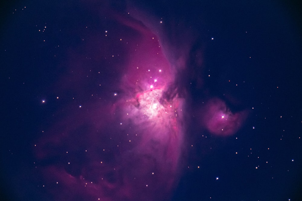 a very bright pink star in the middle of the night sky