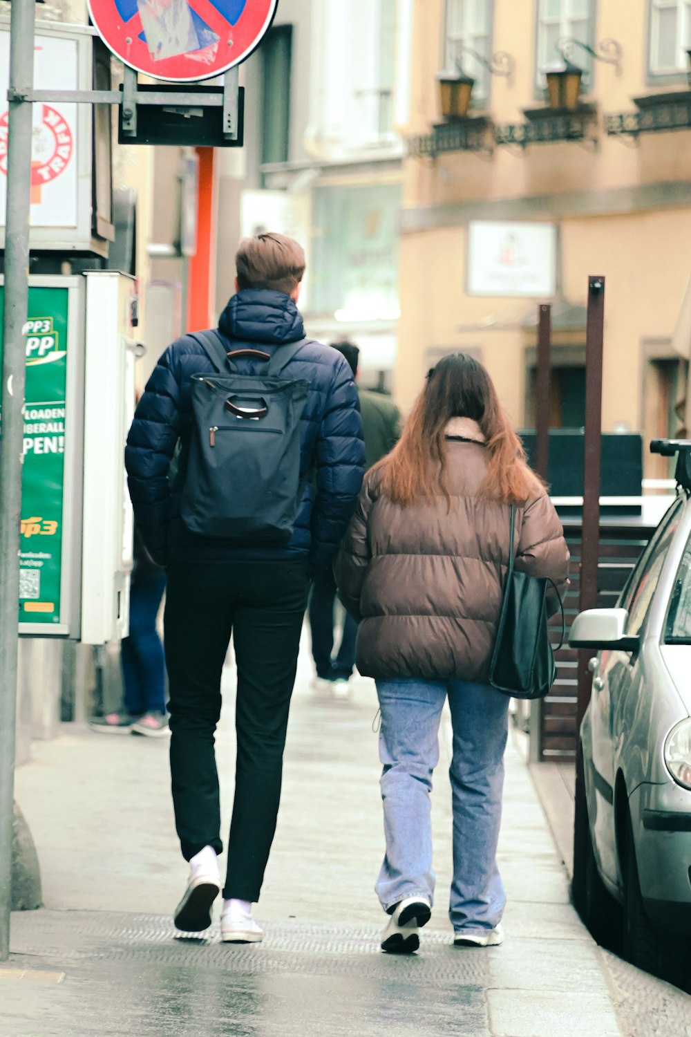 a man and a woman walking down a sidewalk